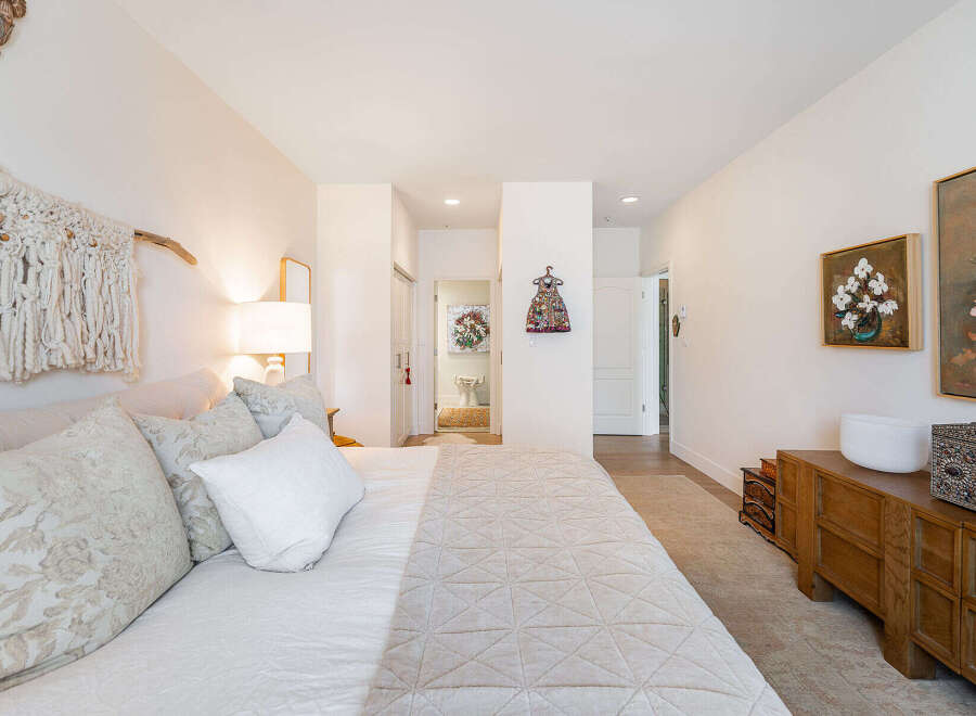 Experience comfort and style in this beautifully appointed bedroom, featuring a plush bed adorned with decorative pillows and a textured quilt.