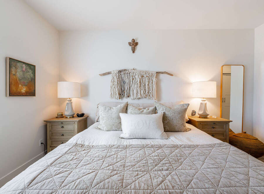 This serene bedroom features a cozy queen-size bed adorned with plush pillows and a textured quilt, creating an inviting atmosphere.