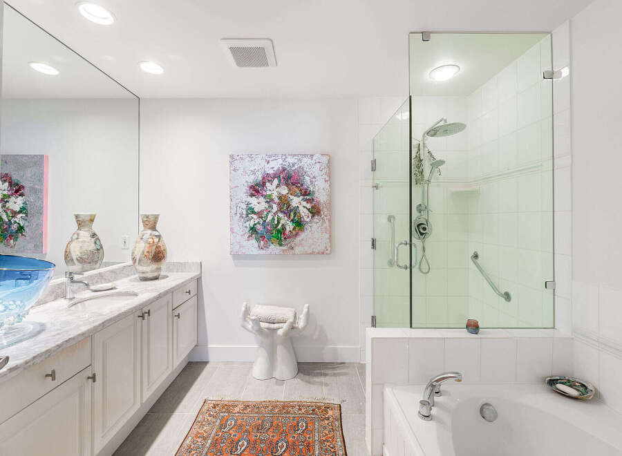 Indulge in luxury in this stunning master bathroom, featuring a spacious walk-in shower with a rainfall showerhead and a deep soaking tub perfect for relaxation.