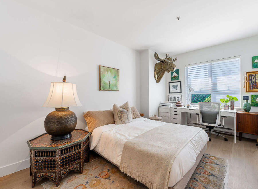 This charming bedroom features a comfortable queen-size bed adorned with plush pillows and a cozy throw blanket, perfect for relaxation.