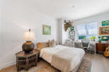 This charming bedroom features a comfortable queen-size bed adorned with plush pillows and a cozy throw blanket, perfect for relaxation.