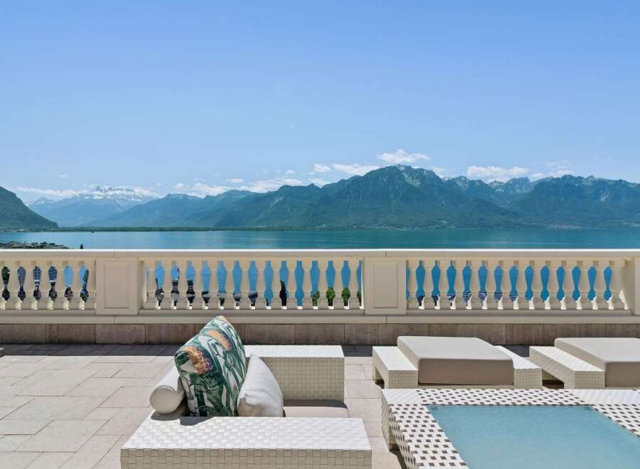 Experience breathtaking panoramic views of snow-capped mountains and a serene lake from this exquisite property's expansive terrace.