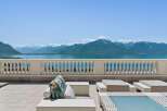 Experience breathtaking panoramic views of snow-capped mountains and a serene lake from this exquisite property's expansive terrace.