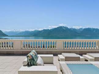 Experience breathtaking panoramic views of snow-capped mountains and a serene lake from this exquisite property's expansive terrace.