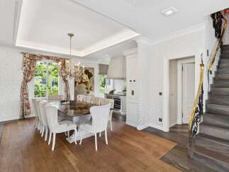 Experience elegant dining in this luxurious home, featuring a spacious dining room with a grand chandelier and seating for ten.