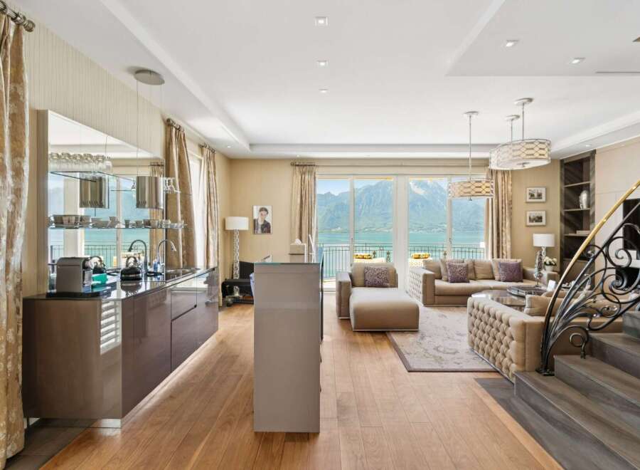 Experience luxury living with this stunning apartment featuring a modern kitchen and spacious living area with breathtaking lake and mountain views.