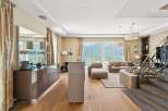 Experience luxury living with this stunning apartment featuring a modern kitchen and spacious living area with breathtaking lake and mountain views.