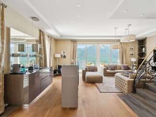 Experience luxury living with this stunning apartment featuring a modern kitchen and spacious living area with breathtaking lake and mountain views.