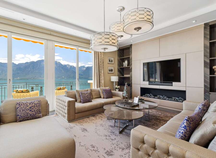 Experience luxury living with breathtaking mountain and lake views from this stunning living room.