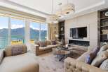 Experience luxury living with breathtaking mountain and lake views from this stunning living room.