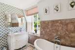 Indulge in luxury with this stunning bathroom featuring a freestanding bathtub and a sophisticated vanity.