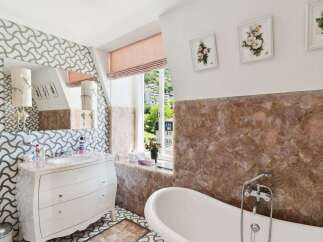 Indulge in luxury with this stunning bathroom featuring a freestanding bathtub and a sophisticated vanity.