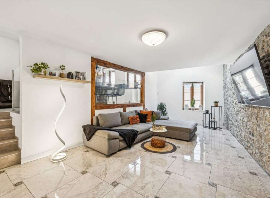 Experience modern living in this stylish living room featuring a spacious sectional sofa and a unique spiral floor lamp.