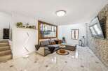 Experience modern living in this stylish living room featuring a spacious sectional sofa and a unique spiral floor lamp.