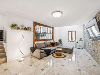 Experience modern living in this stylish living room featuring a spacious sectional sofa and a unique spiral floor lamp.