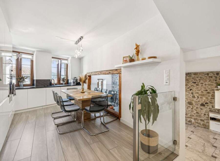 Experience modern living in this bright and airy dining area, seamlessly connected to a sleek kitchen.