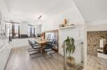 Experience modern living in this bright and airy dining area, seamlessly connected to a sleek kitchen.