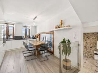 Experience modern living in this bright and airy dining area, seamlessly connected to a sleek kitchen.