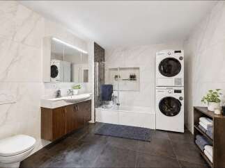This modern bathroom features a sleek vanity with a vessel sink, a wall-mounted toilet, and a bathtub with a glass shower enclosure.