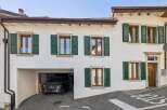 Charming traditional home featuring a spacious garage and multiple windows with classic green shutters.