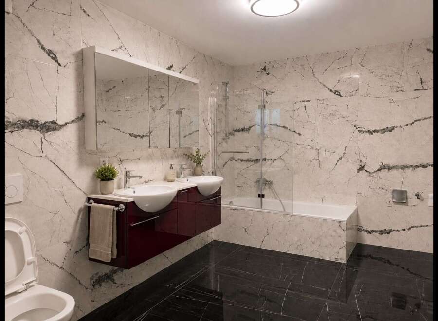 Experience modern luxury in this stunning bathroom featuring elegant marble-patterned walls and sleek black marble floors.