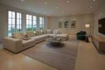 Experience luxurious living in this spacious living room, featuring a large sectional sofa perfect for gatherings and a modern coffee table.