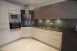 Experience modern living in this sleek kitchen featuring a built-in stainless steel oven and microwave.