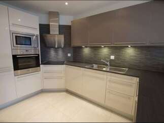 Experience modern living in this sleek kitchen featuring a built-in stainless steel oven and microwave.