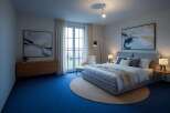 Experience modern comfort in this beautifully appointed bedroom, featuring a plush king-sized bed and elegant abstract artwork.