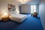 Experience modern comfort in this beautifully appointed bedroom, featuring a plush king-size bed with crisp white linens and two matching nightstands with elegant mushroom-shaped lamps.