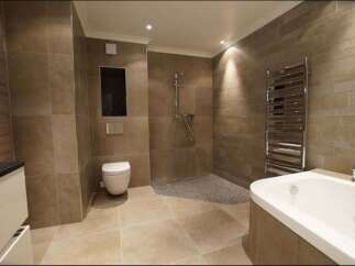 Experience luxury in this modern bathroom featuring a spacious soaking tub and a walk-in shower with pebble flooring.
