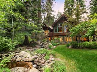 Nestled amidst lush greenery and mature trees, this stunning mountain home offers a serene retreat.