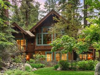 Nestled amidst towering trees, this stunning mountain home offers a serene retreat with its rustic charm and natural beauty.