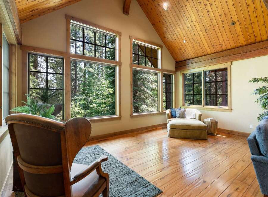 Experience breathtaking forest views from this stunning living space, featuring expansive windows that flood the room with natural light.