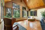 Experience breathtaking forest views from this stunning living space, featuring expansive windows that flood the room with natural light.