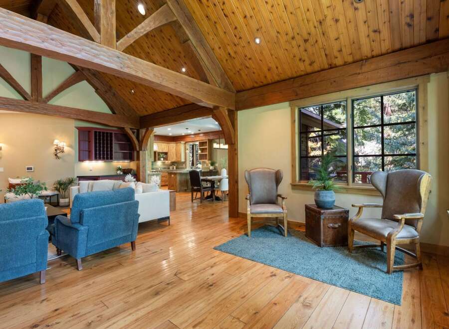 Experience rustic elegance in this spacious living area, featuring a stunning vaulted ceiling with exposed wooden beams and a warm, inviting atmosphere.