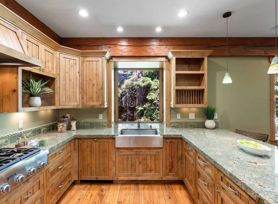 Experience rustic charm in this beautifully appointed kitchen, featuring warm, natural wood cabinetry and a stunning farmhouse sink.