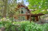Nestled amidst lush greenery, this stunning mountain home offers a serene retreat with its natural wood siding and stone accents.