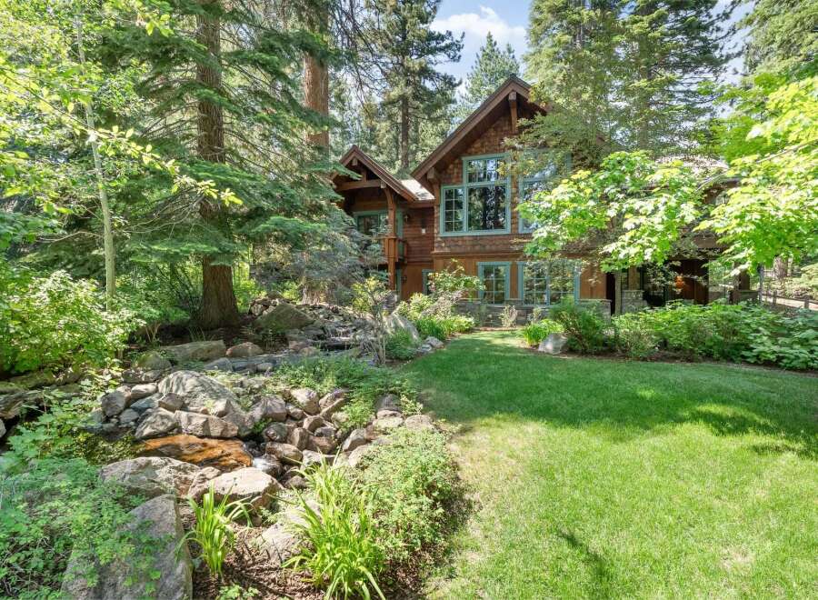 Nestled amidst lush greenery and mature trees, this stunning mountain home offers a serene retreat.