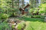 Nestled amidst lush greenery and mature trees, this stunning mountain home offers a serene retreat.