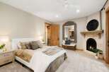 Experience ultimate comfort in this luxurious bedroom, featuring a cozy fireplace and a large ornate mirror.