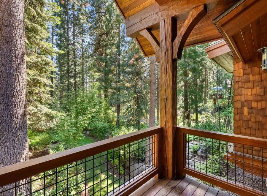 Experience the tranquility of nature from this stunning wooden balcony, offering breathtaking views of a lush forest.