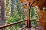 Experience the tranquility of nature from this stunning wooden balcony, offering breathtaking views of a lush forest.