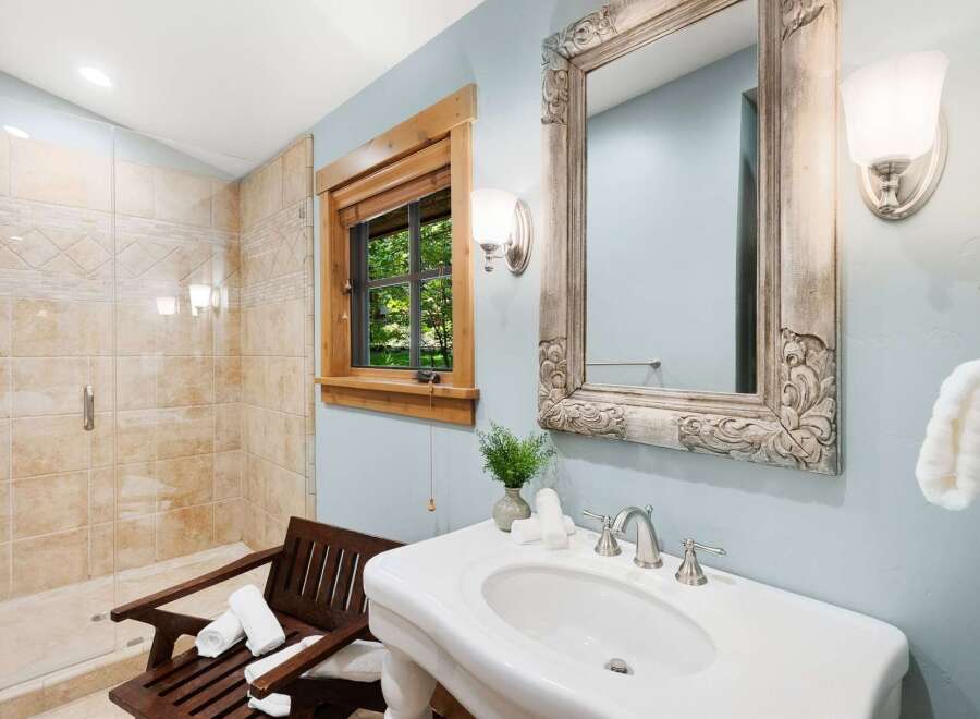 This charming bathroom features a spacious walk-in shower with elegant tilework and a built-in bench.