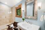 This charming bathroom features a spacious walk-in shower with elegant tilework and a built-in bench.