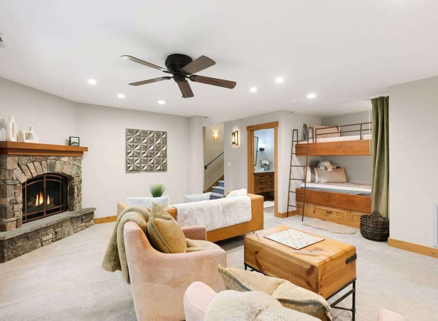 Cozy up by the stone fireplace in this inviting living space, perfect for family gatherings.