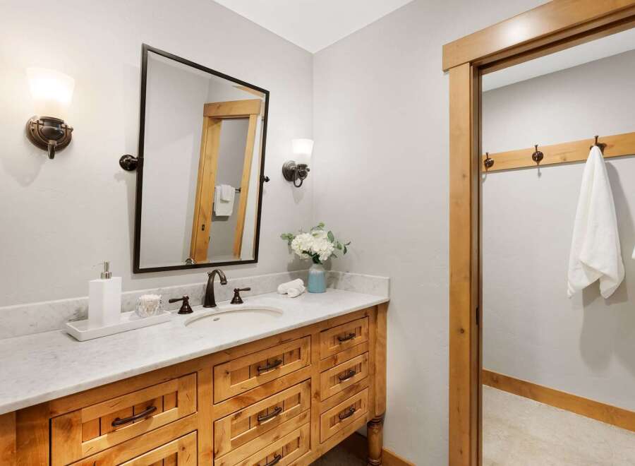 This bathroom features a rustic wooden vanity with ample drawer storage and a marble countertop.