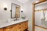 This bathroom features a rustic wooden vanity with ample drawer storage and a marble countertop.