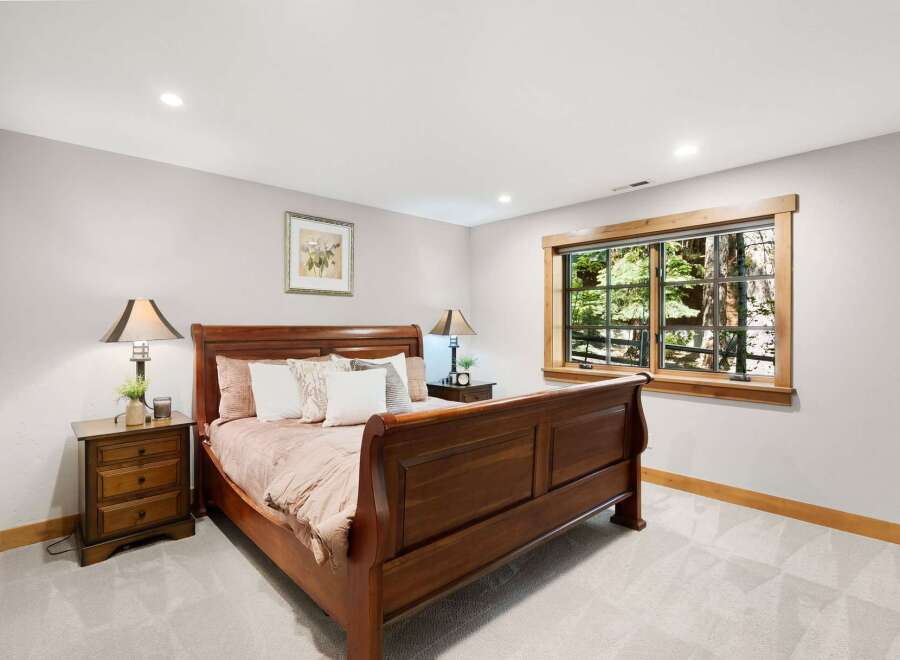 Experience serene living in this charming bedroom, featuring a beautiful wooden sleigh bed and coordinating nightstands.