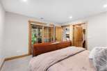 Experience rustic charm in this inviting bedroom featuring a warm wooden sleigh bed and direct access to the outdoors through elegant glass doors.